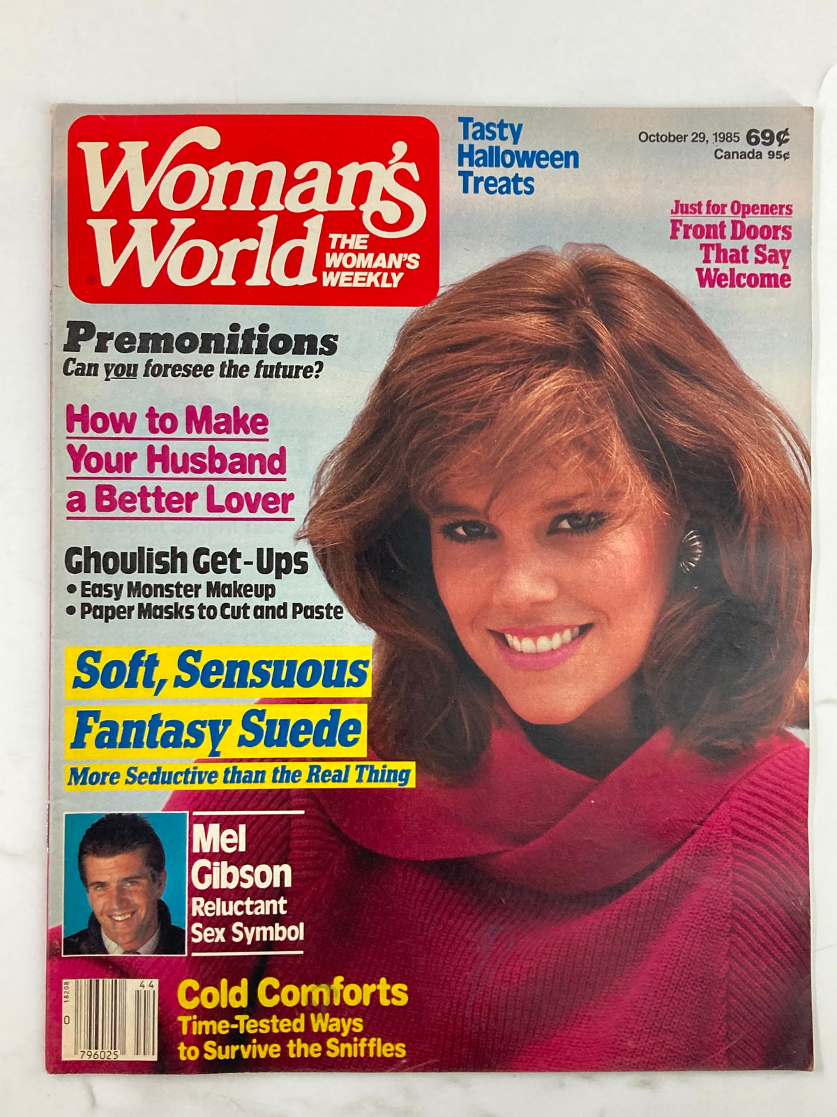 Cover of Woman's World Magazine October 29, 1985, featuring Mel Gibson as a sex symbol, with various articles including 'How to Make Your Husband a Better Lover' and 'Soft, Sensuous Fantasy Suede'. The magazine is in good condition and comes with a plastic protective covering.