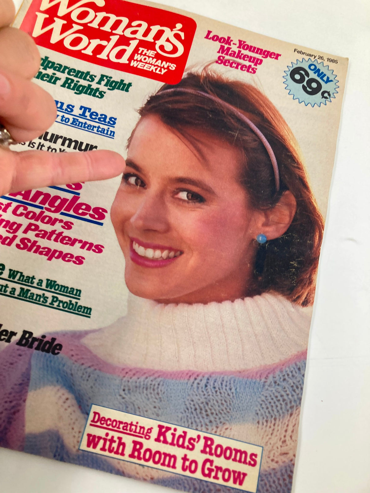 Close-up of the cover of Woman's World Magazine from February 26, 1985, showing the smiling woman in a patterned sweater, with article highlights such as 'Delicious Teas' and 'Impotence: What a Woman Should Know'.