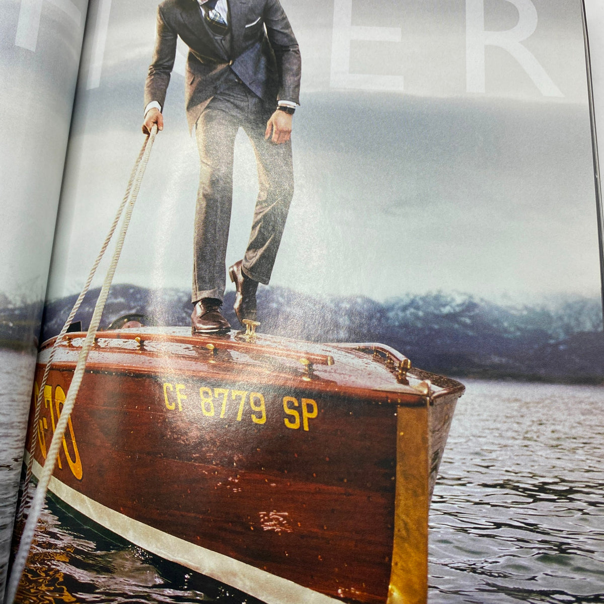 Inside spread from Vogue Magazine September 2008, depicting a stylish man in a suit standing on a boat, highlighting luxury fashion trends.