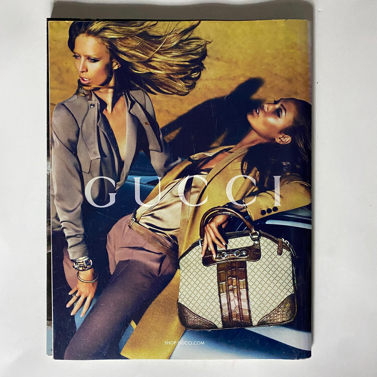 Gucci advertisement featured in Vogue UK Magazine August 2010, showcasing luxury fashion with models highlighting stylish bags and contemporary designs.