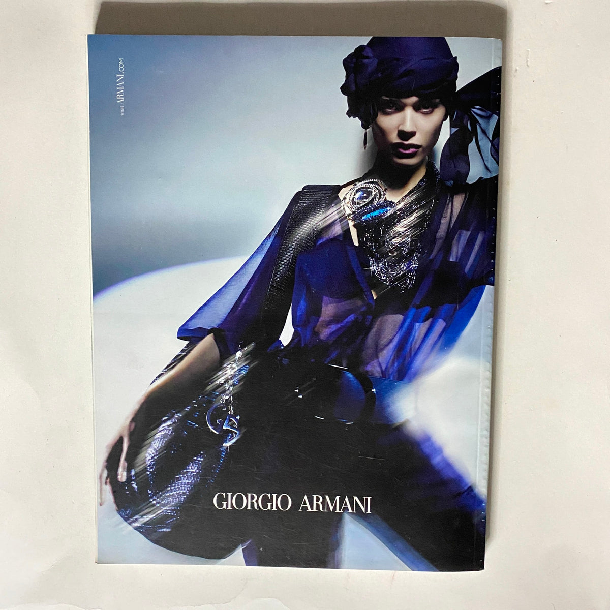 Giorgio Armani advertisement from Vogue Italia Magazine April 2011, showcasing an elegant model wearing an avant-garde outfit with striking accessories.