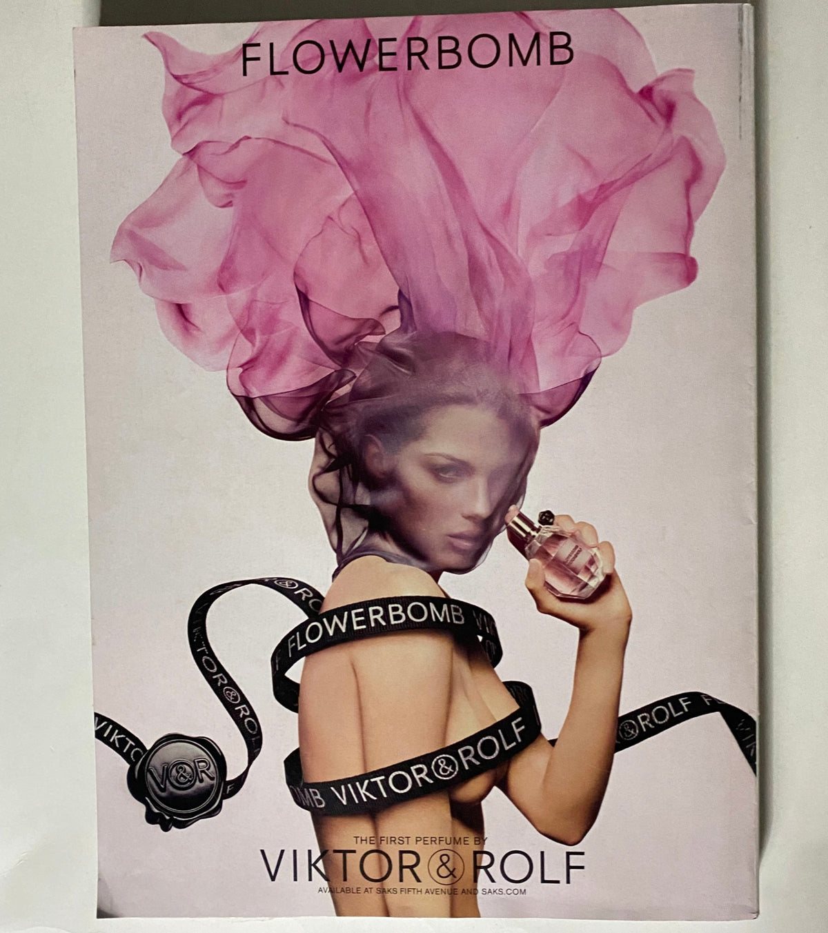 Vogue Magazine April 2007 advertisement for Flowerbomb by Viktor & Rolf, featuring a model draped in pink smoke holding the fragrance, embodying elegance and allure.