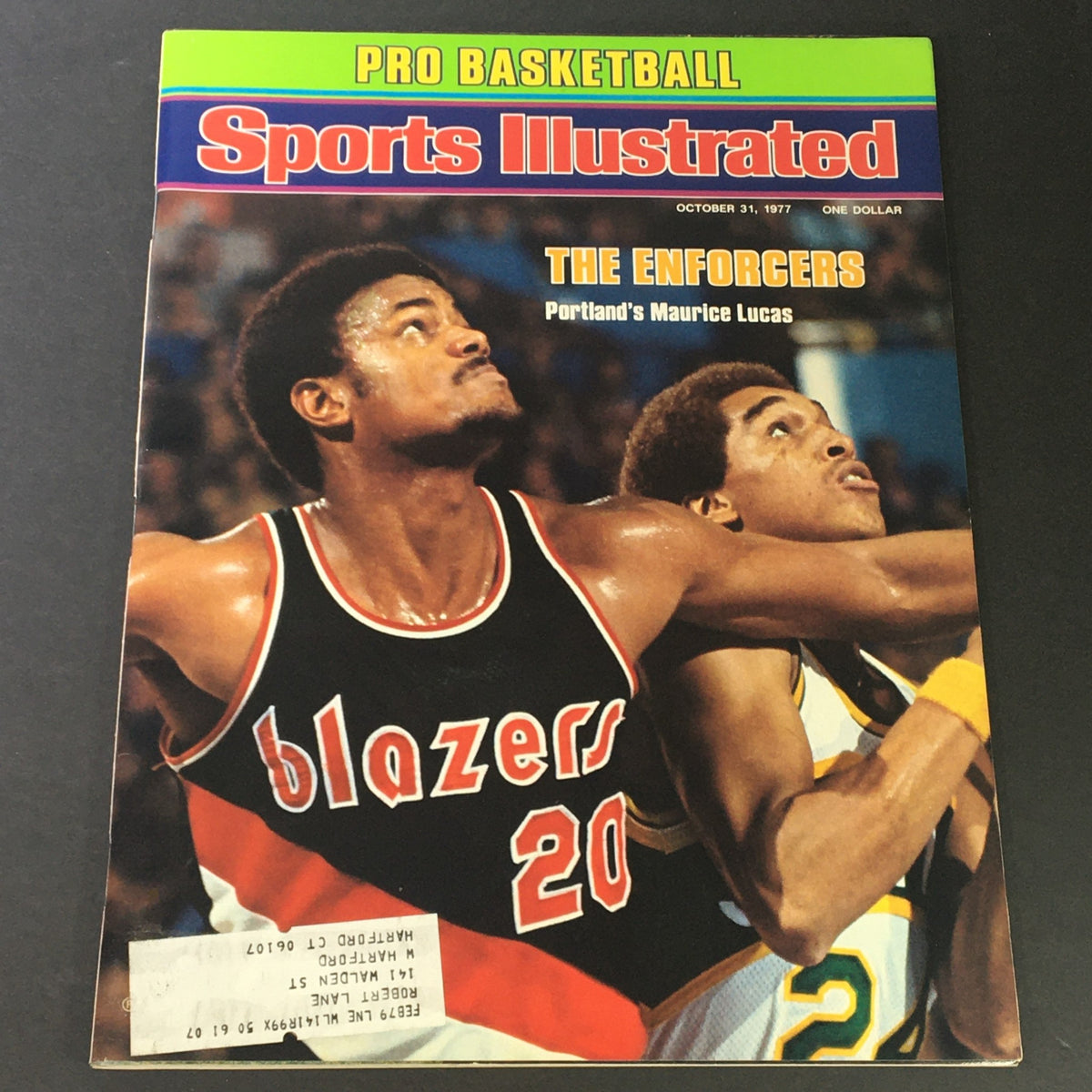 Cover of Sports Illustrated Magazine dated October 31, 1977, featuring Portland's Maurice Lucas and another player. The magazine highlights the topic 'The Enforcers'.