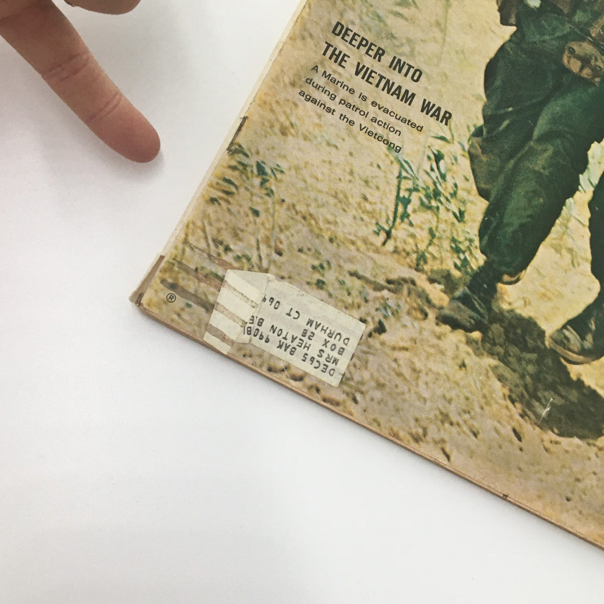 Detail of VTG Life Magazine July 2 1965 cover featuring 'Deeper Into The Vietnam War' with a Marine being evacuated during patrol action against the Viet Cong. The image shows the magazine's edge and a label on the back.