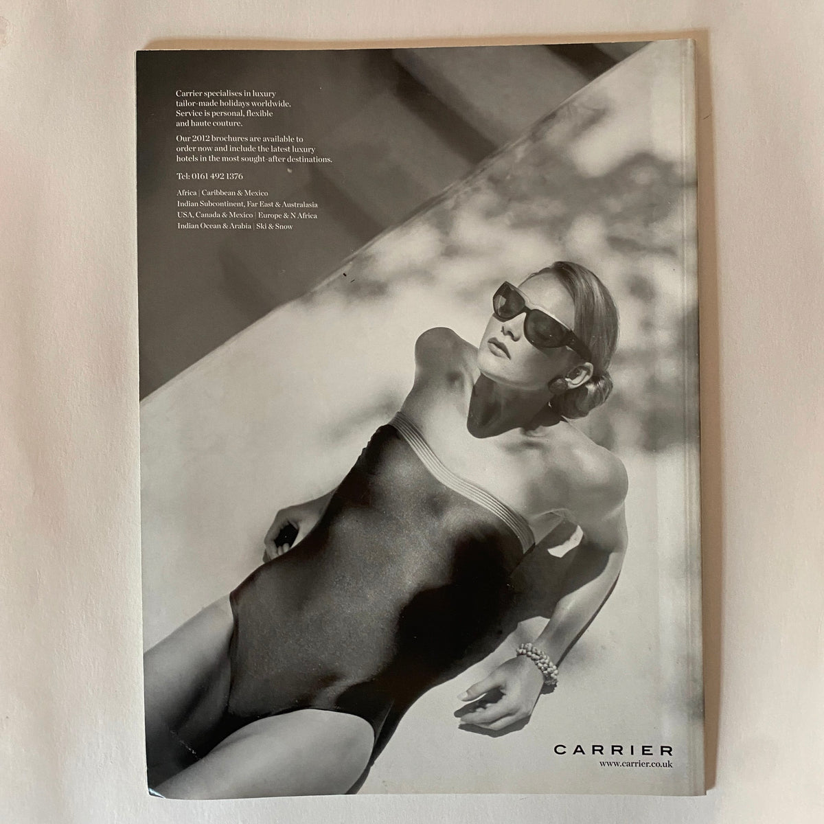 Back cover of Harper's Bazaar Magazine January 2012 featuring an elegant black and white image of a model in a swimsuit, promoting luxury travel.