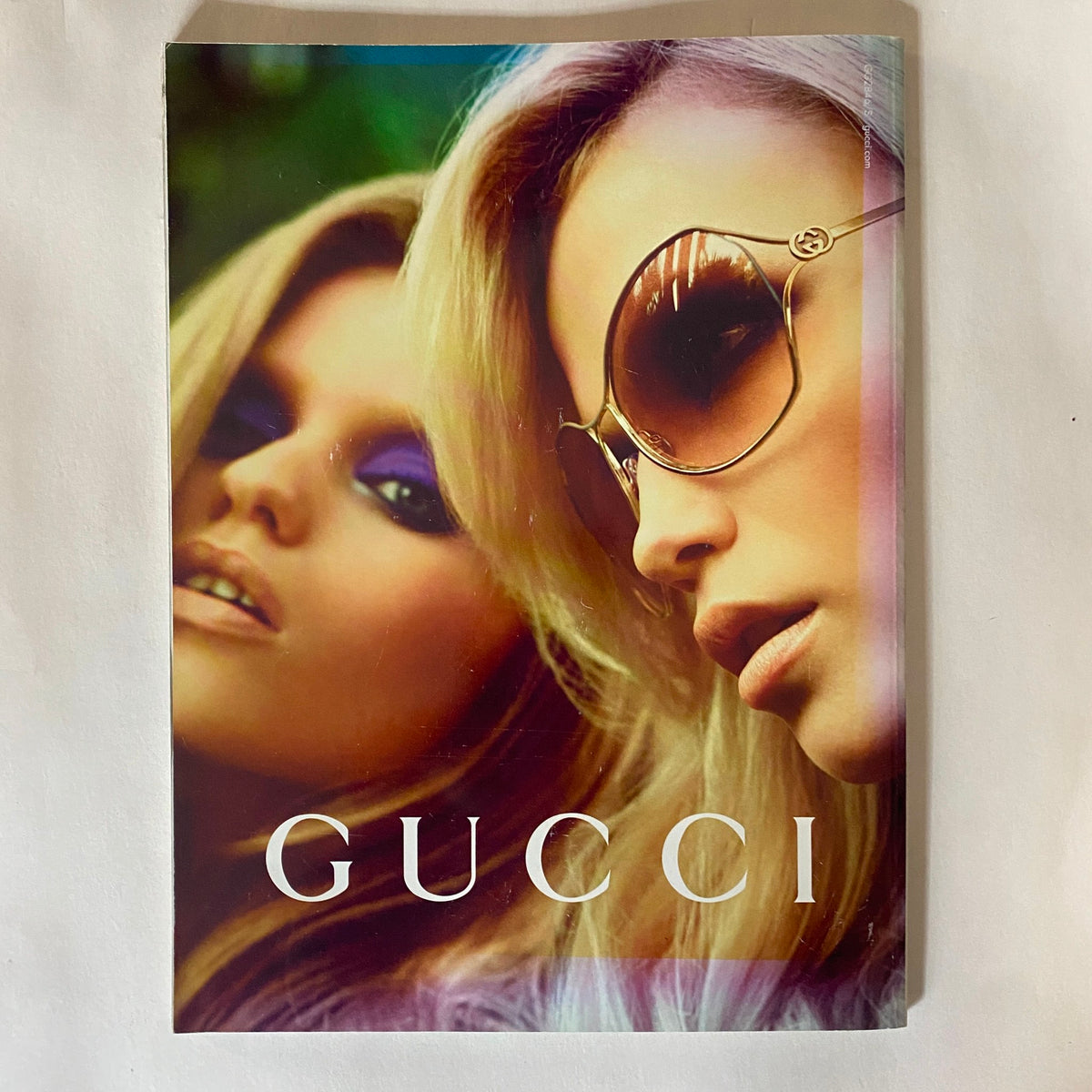 Gucci promotional magazine cover featuring glamorous models showcasing contemporary fashion and beauty trends.