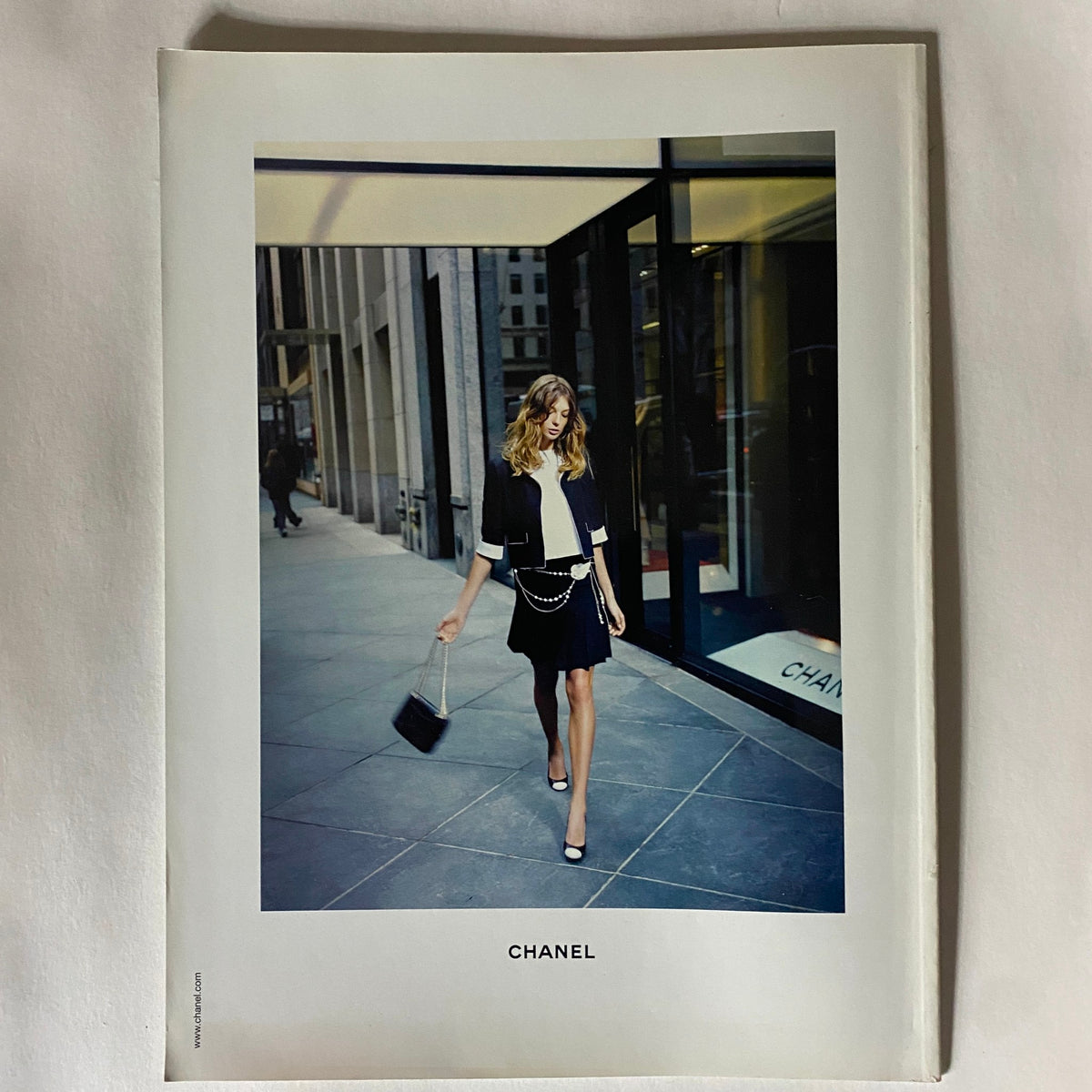 Chanel advertisement included in Harpers Business Magazine October 2005, displaying a stylish woman in a fashionable outfit walking along a city street.