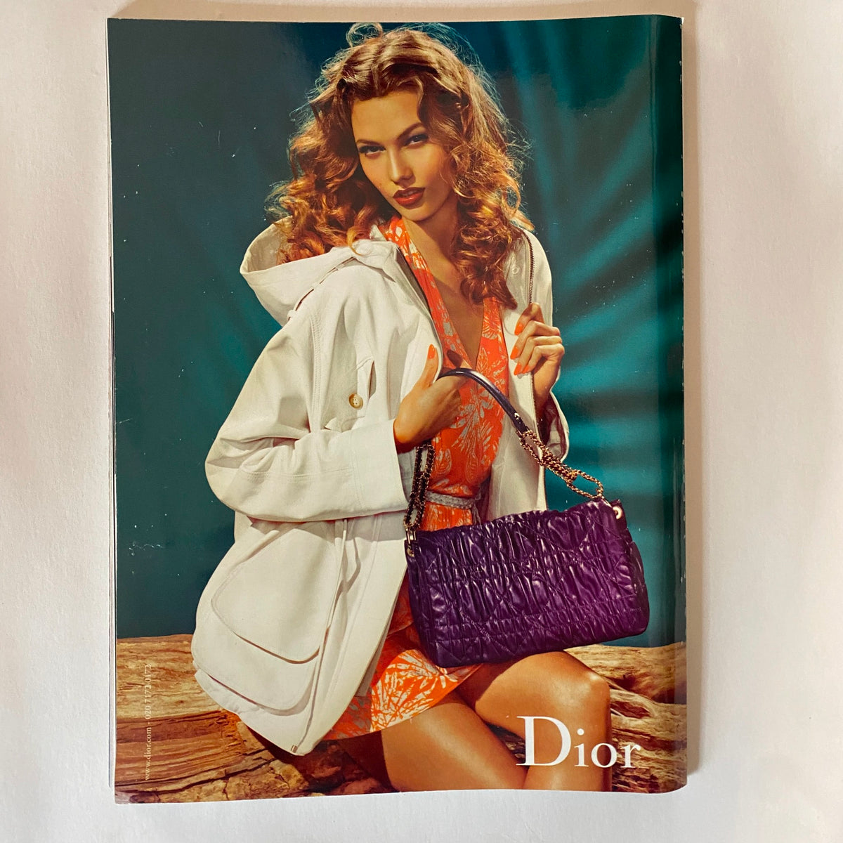 Cover of a Dior advertisement featuring a model in a chic outfit with a stylish handbag, capturing the essence of luxury fashion in Harper's Bazaar UK Magazine February 2011.