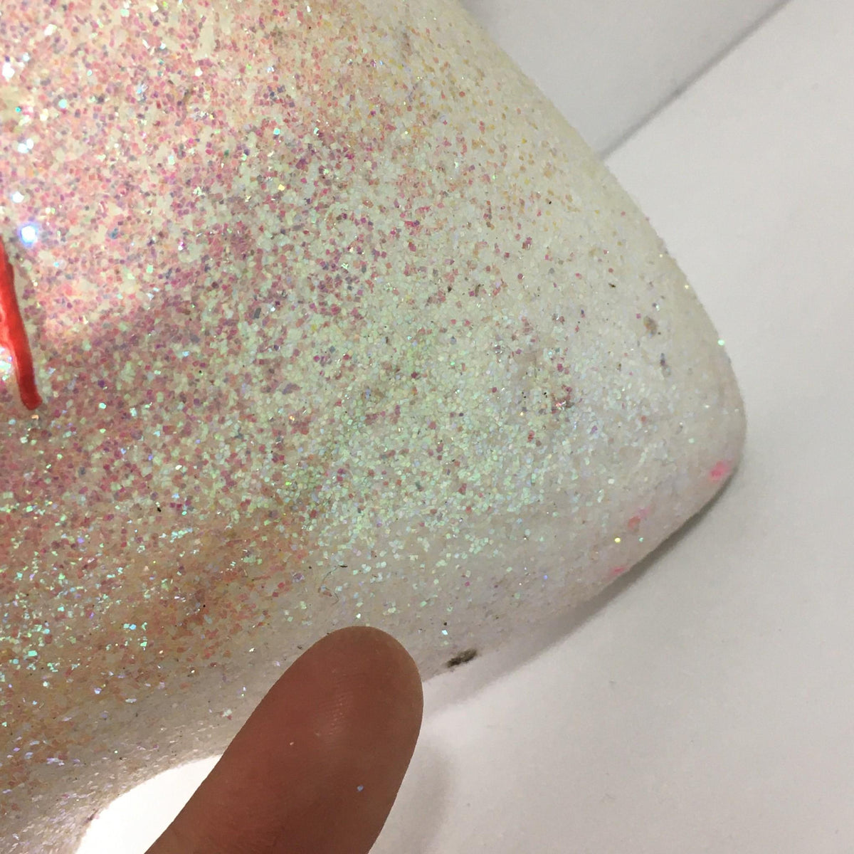 Side view of the glittery finish on the Macy's Thanksgiving Day Parade 75th Anniversary Collectible star ornament, emphasizing its shiny texture and celebratory appeal.