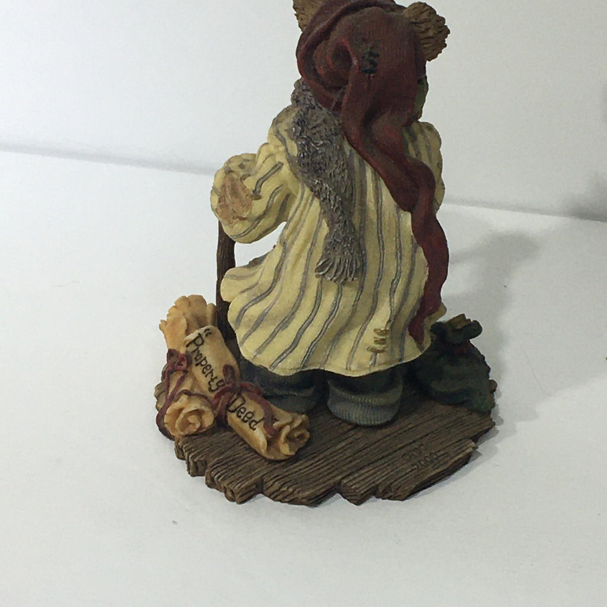 Bearstone Collection style #228333 PAW Scrooge McBear figurine depicting a character in a striped coat with a scarf, holding a walking stick, symbolizing holiday spirit and cheer. Bah Humbug!
