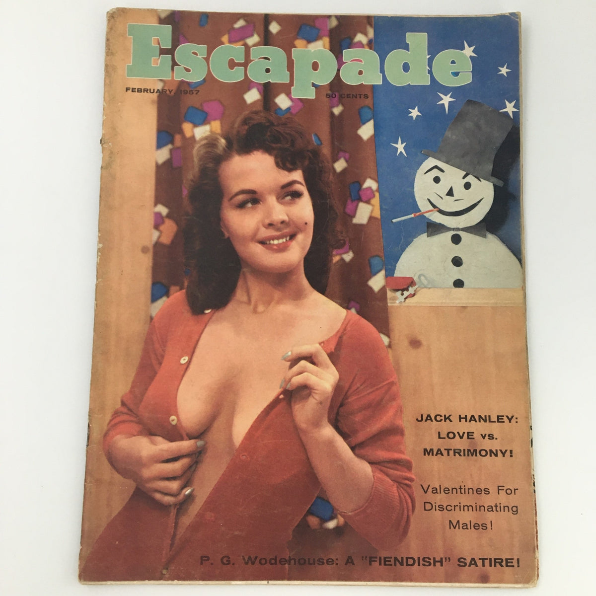 Cover of VTG Escapade Magazine from February 1957, featuring a smiling woman in a cardigan, vibrant colors, and a playful snowman illustration. This vintage publication includes a love feature by Jack Hanley and highlights the romantic ideals of the era.