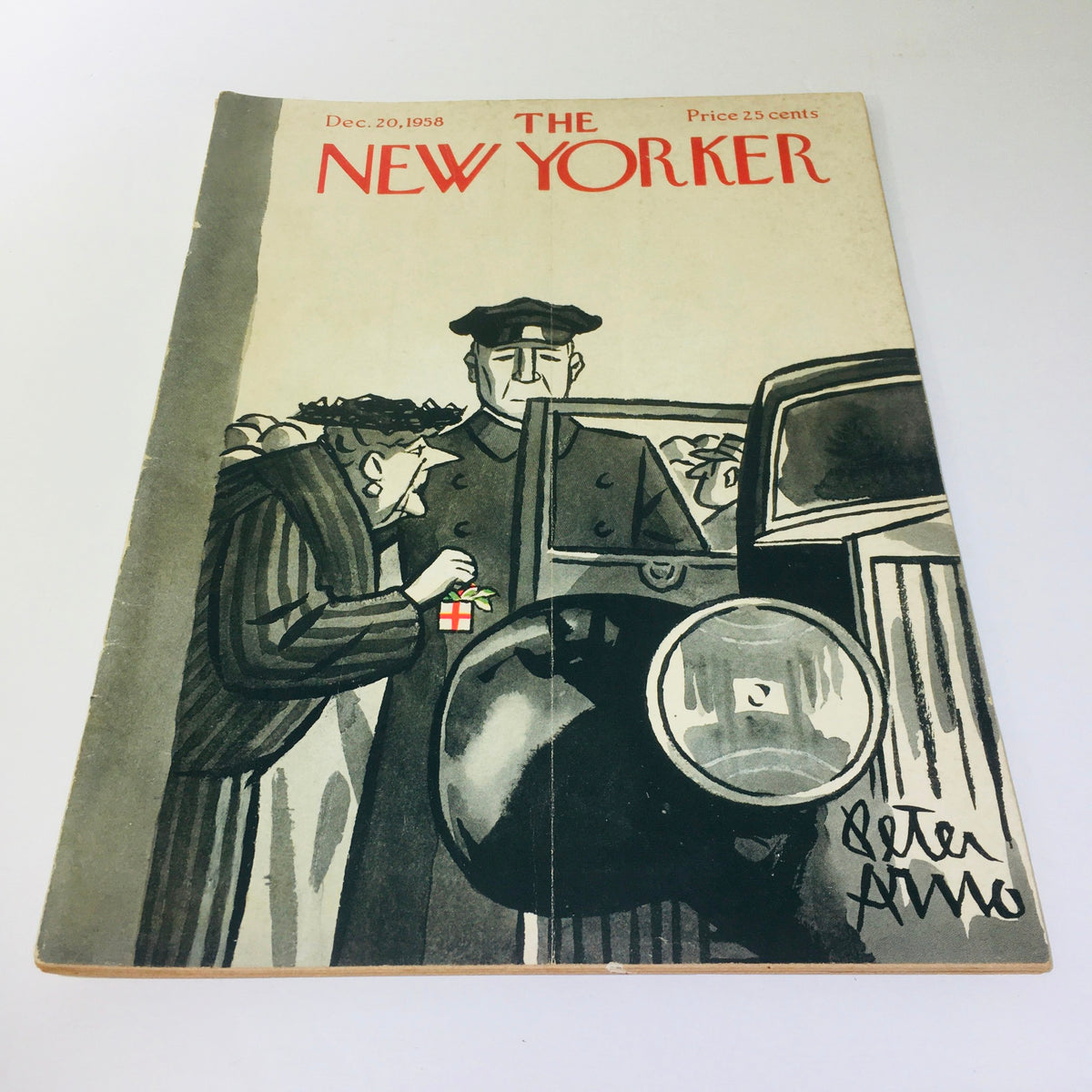 The New Yorker: Dec 20 1958 magazine cover featuring an illustration by Peter Arno, depicting a woman holding a gift and a man in a black coat, showcasing the distinct artistic style of mid-20th century. Vintage collectible perfect for enthusiasts of American journalism.