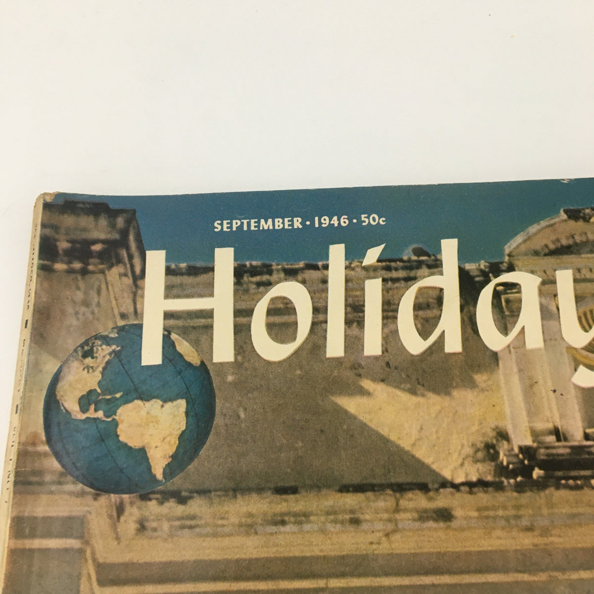 Close-up of the VTG Holiday Magazine September 1946 cover, displaying the magazine title and a globe illustration, emphasizing its vintage appeal and connection to cultural themes of the late 1940s.