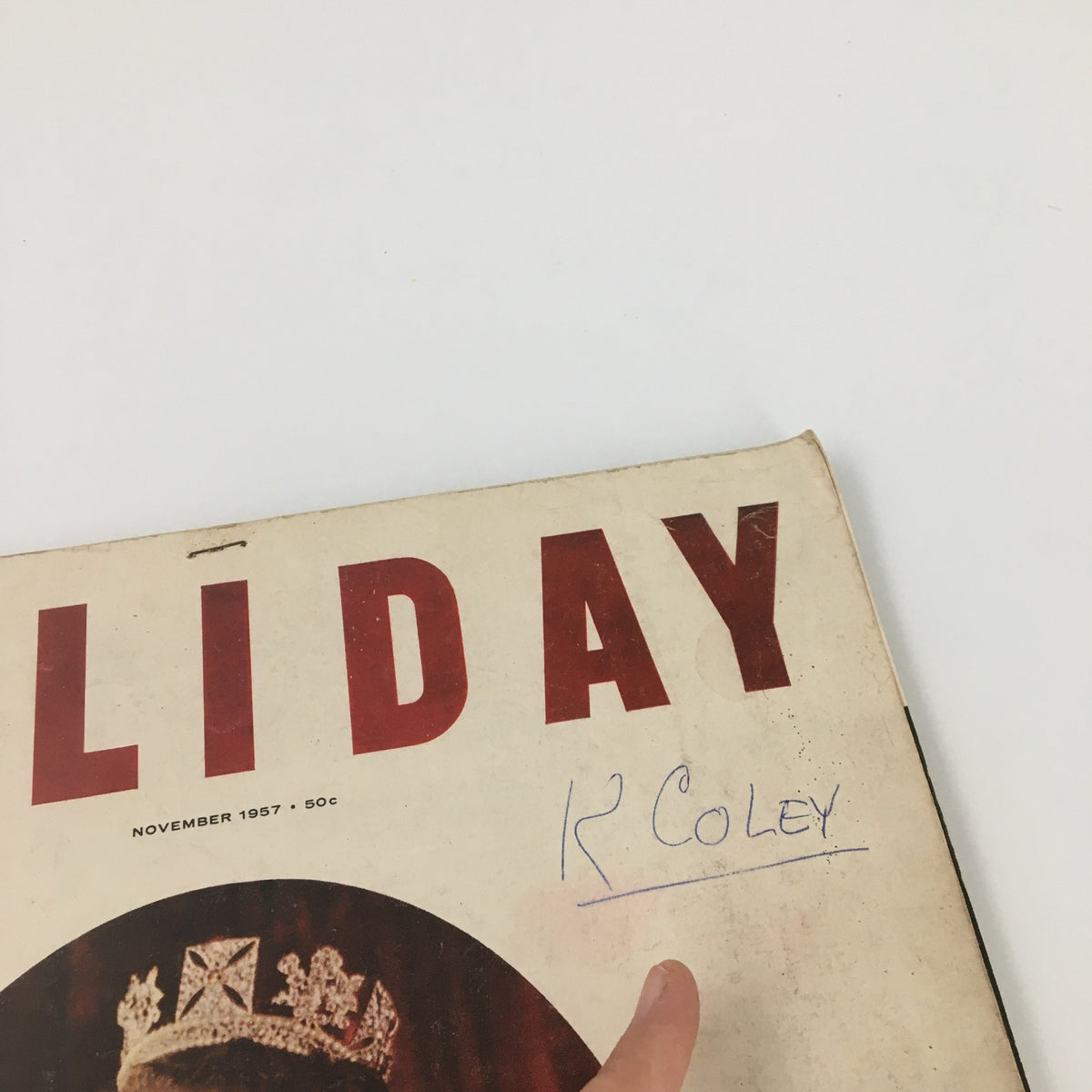 Close-up of the VTG Holiday Magazine November 1957 cover, showing the title 'HOLIDAY' and handwritten note 'R COLEY'. Vintage magazine highlighting Queen Elizabeth.