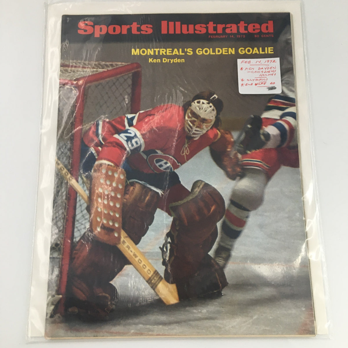 Sports Illustrated magazine from February 14, 1972, featuring Ken Dryden, displayed in a protective sleeve, indicating its collectible status.