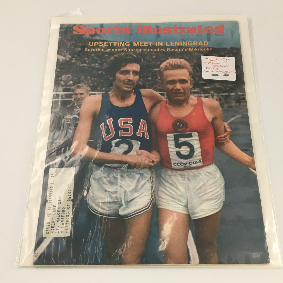 Sports Illustrated August 3, 1970, cover displayed in protective plastic. The cover features Frank Shorter and another runner, commemorating their notable race.