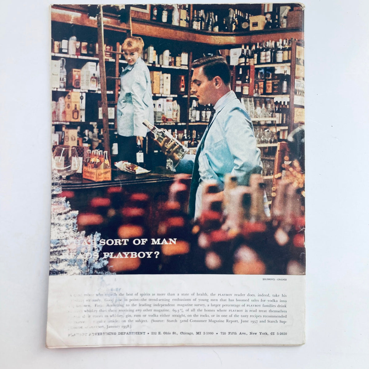 Back cover of VTG Playboy Magazine August 1958 depicting a vintage scene in a bar with a man in a blue coat holding a bottle, illustrating the cultural context of the era.