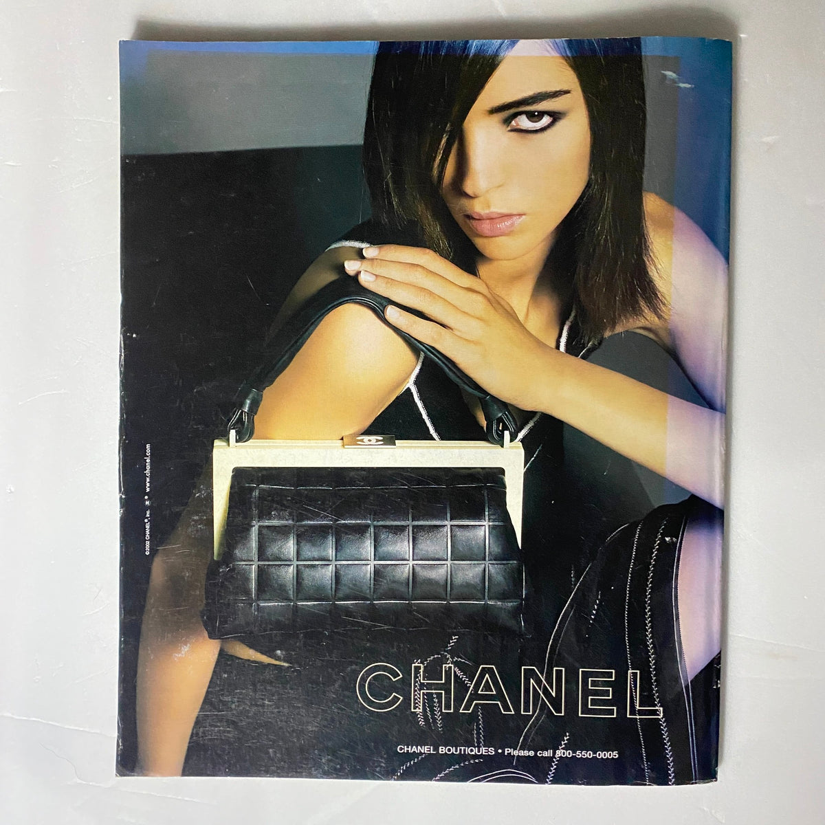 The New York Times Magazine Spring 2002 Part 2 highlighting a striking Chanel advertisement with a model showcasing a chic black handbag.