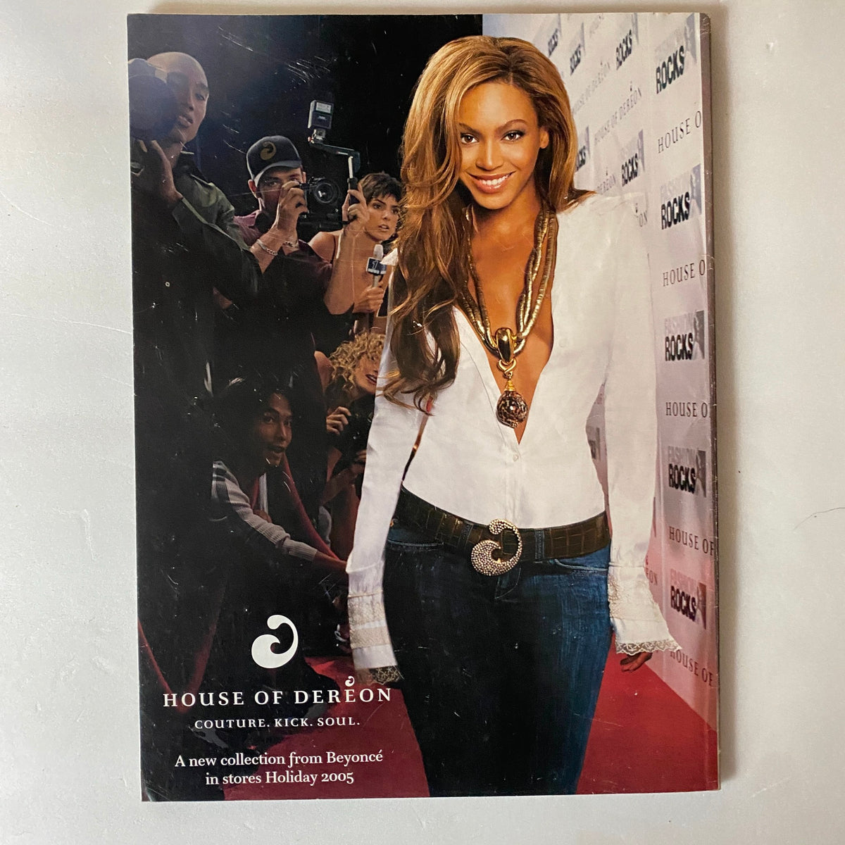 Beyoncé posing at a red carpet event, wearing a stylish outfit and bold jewelry, promoting her new collection, House of Deréon. Featured in the Fashion Rocks Supplement to W Magazine October 2005.