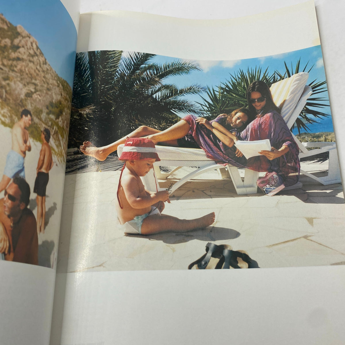 A vibrant beach scene from Elle UK Magazine April 2003 showing a woman lounging with children, depicting a relaxed and stylish summer atmosphere.