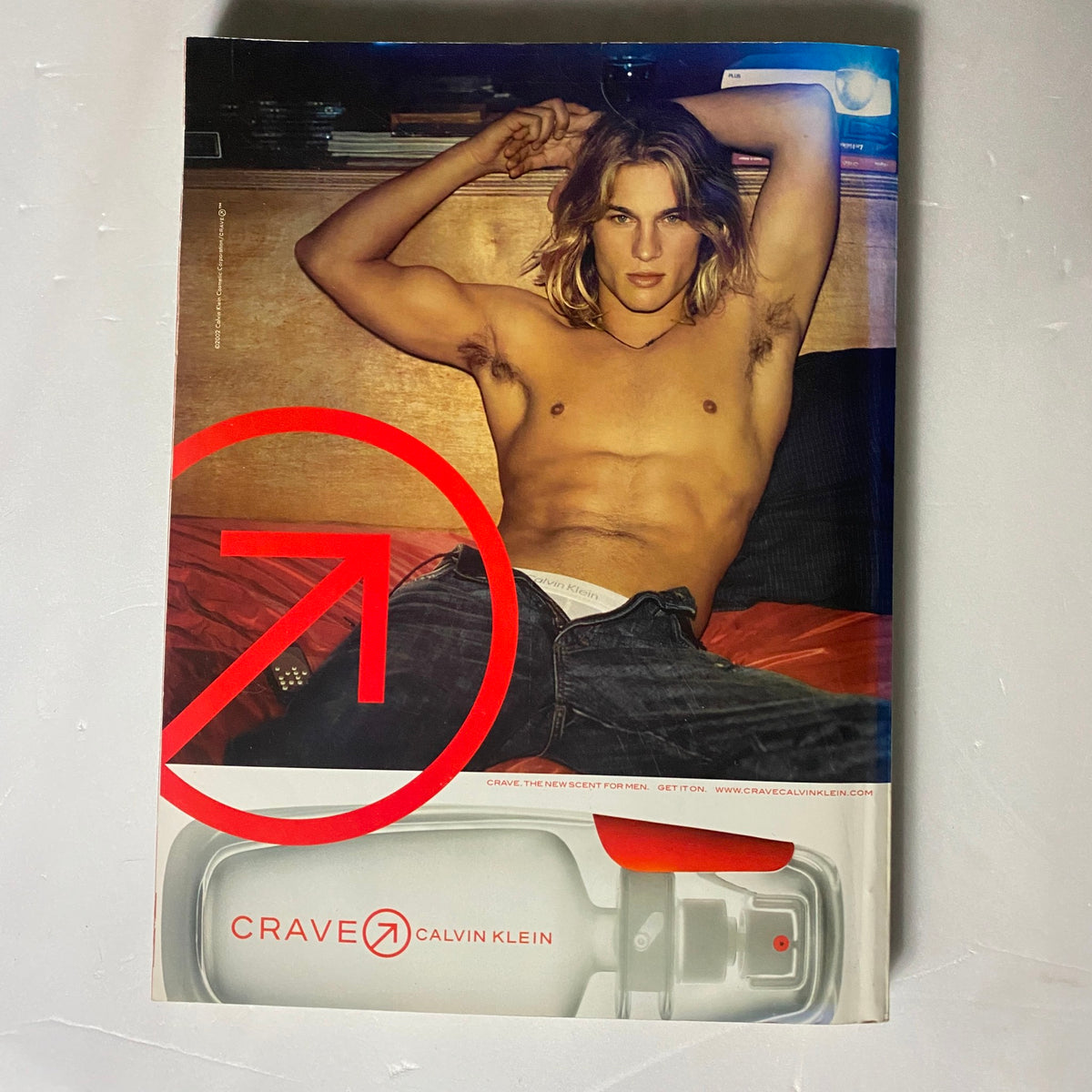 The back cover of Elle UK Magazine April 2003 featuring a Calvin Klein advertisement with a shirtless male model, emphasizing fashion and contemporary trends.
