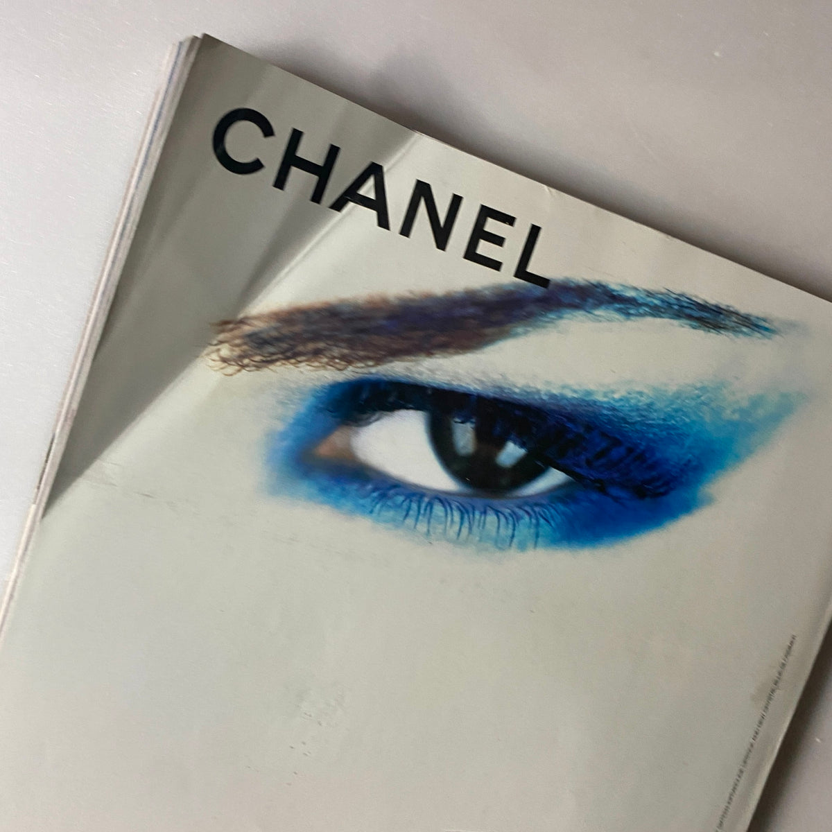 Detail of the cover of Elle Magazine September 2003, featuring supermodel Erin Wasson, showcasing vibrant blue eye makeup with a Chanel branding theme.