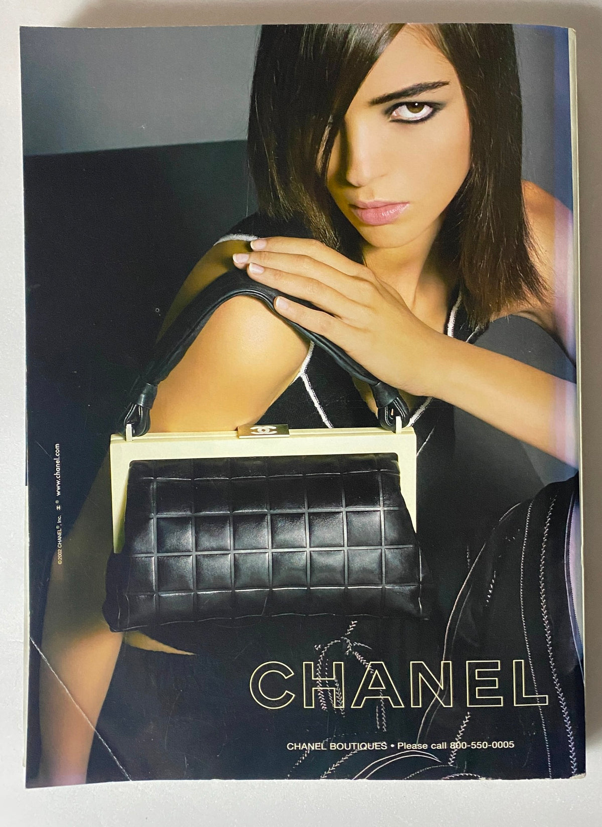 Chanel handbag featured in Vanity Fair Magazine April 2002 with model showcasing a stylish black quilted purse.