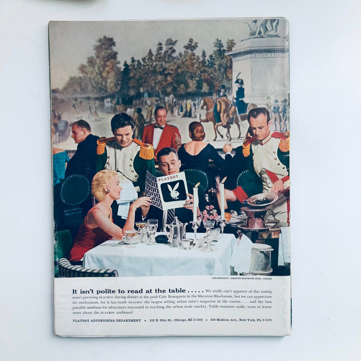 Back cover of VTG Playboy Magazine August 1957 featuring a social dining scene with elegantly dressed guests at a restaurant, showcasing the iconic Playboy logo and vintage aesthetics.
