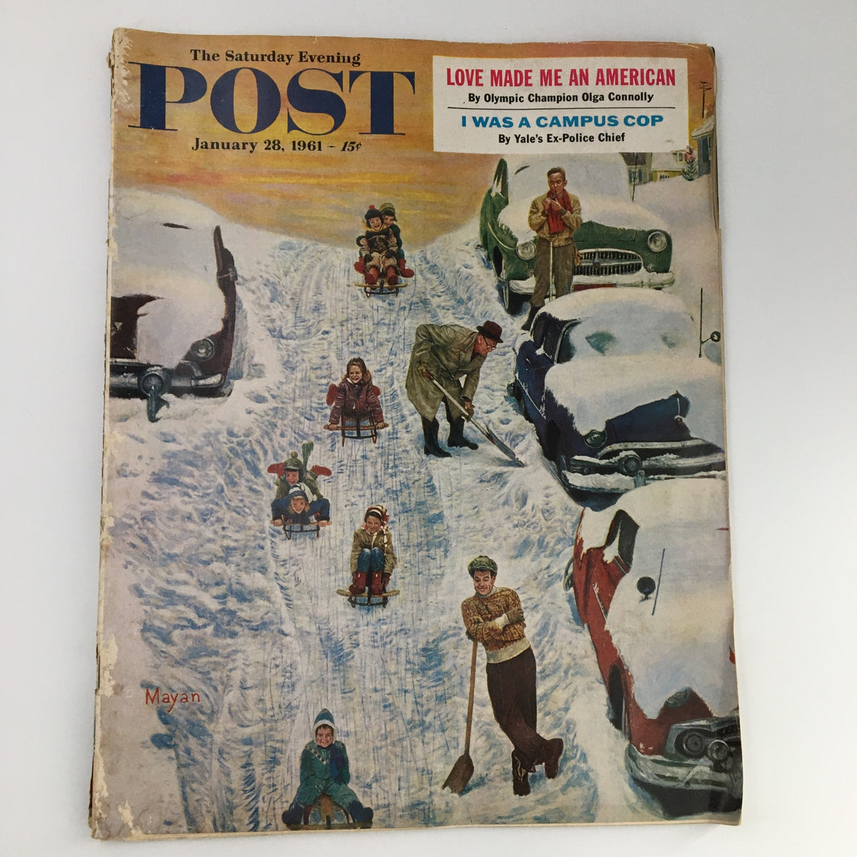 Cover of The Saturday Evening Post, January 28, 1961, featuring a snow-themed illustration with children sledding and a man shoveling snow, capturing the nostalgic essence of the era.