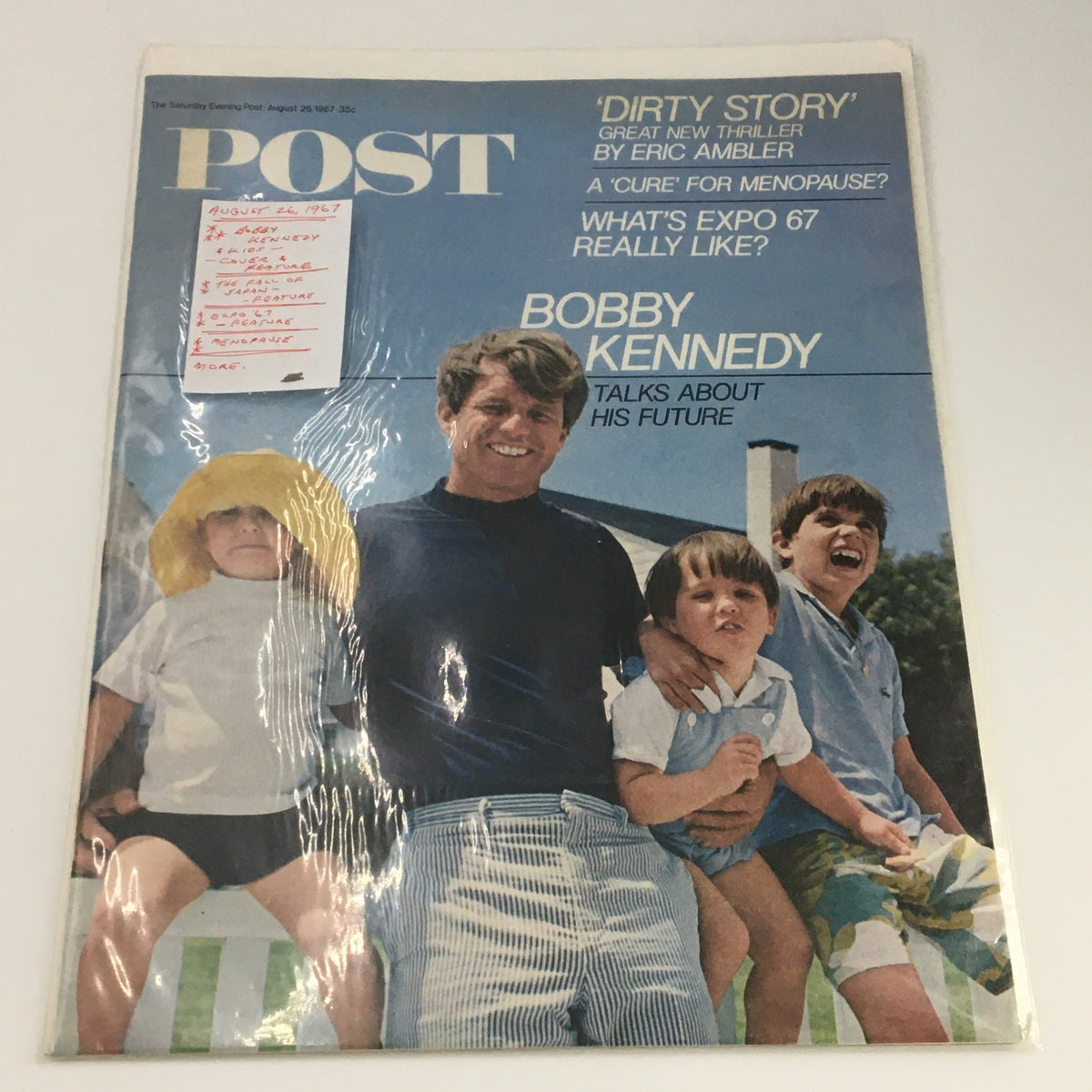 The Saturday Evening Post August 26 1967 cover preserved in protective plastic, displaying Bobby Kennedy with kids, an iconic representation of family and hope.