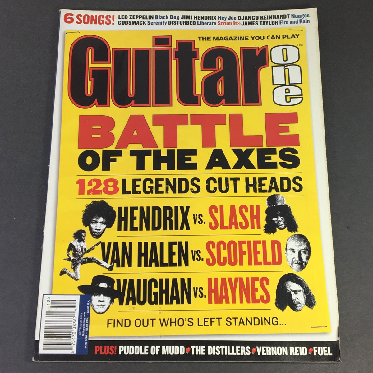 Cover of Guitar One Magazine December 2003 featuring the title 'Battle of the Axes.' Highlights include Jimi Hendrix vs Slash and Vaughan vs Haynes. A collectible vintage magazine for music enthusiasts and guitarists.