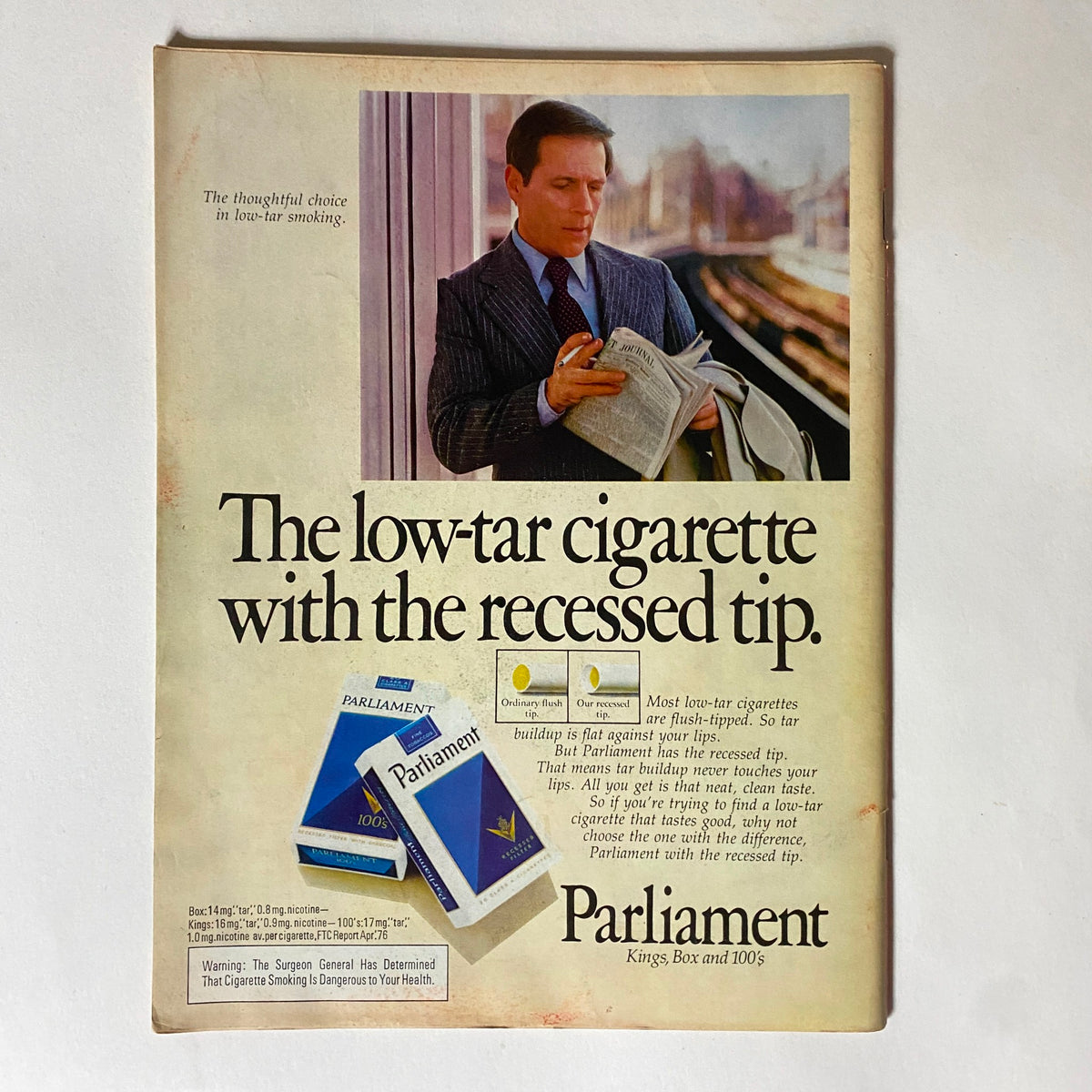 Vintage advertisement featuring a man in a suit reading a newspaper and promoting 'Parliament' low-tar cigarettes, with the tagline 'The low-tar cigarette with the recessed tip,' from the issue of VTG Time Magazine October 25, 1976, titled 'Here Comes King Kong.'