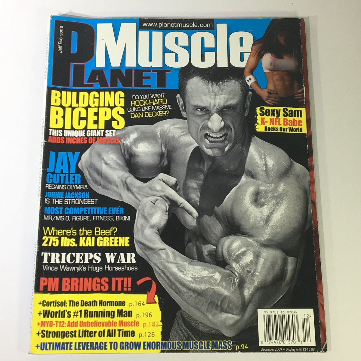 Cover of Planet Muscle Magazine December 2009 featuring Jay Cutler celebrating his victory at the Mr. Olympia title. The magazine highlights bodybuilding topics such as bulging biceps, triceps training, and includes articles about fitness and competition insights.