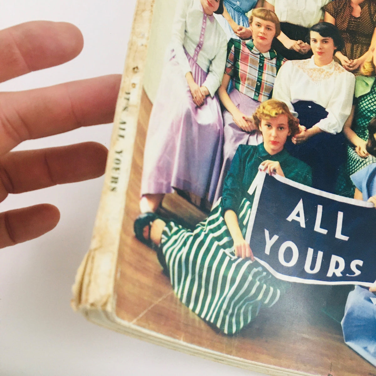 A close-up view of Seventeen Magazine May 1949, highlighting high school girls in vintage attire holding a sign that says 'All Yours', reflecting 1940s teen culture.