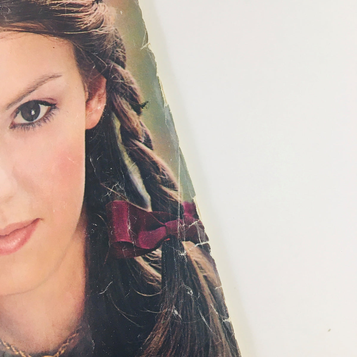 Close-up of a young woman with braids, featuring a red bow, from Seventeen Magazine January 1971.