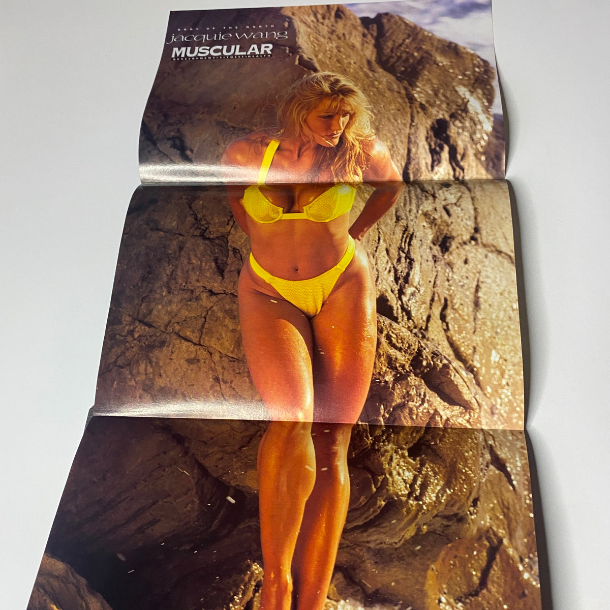 Muscular Development Magazine September 1996 featuring a fold-out poster of Jaquie Wang in a yellow bikini posing on a rocky beach, showcasing the fitness aesthetic of the 1990s.