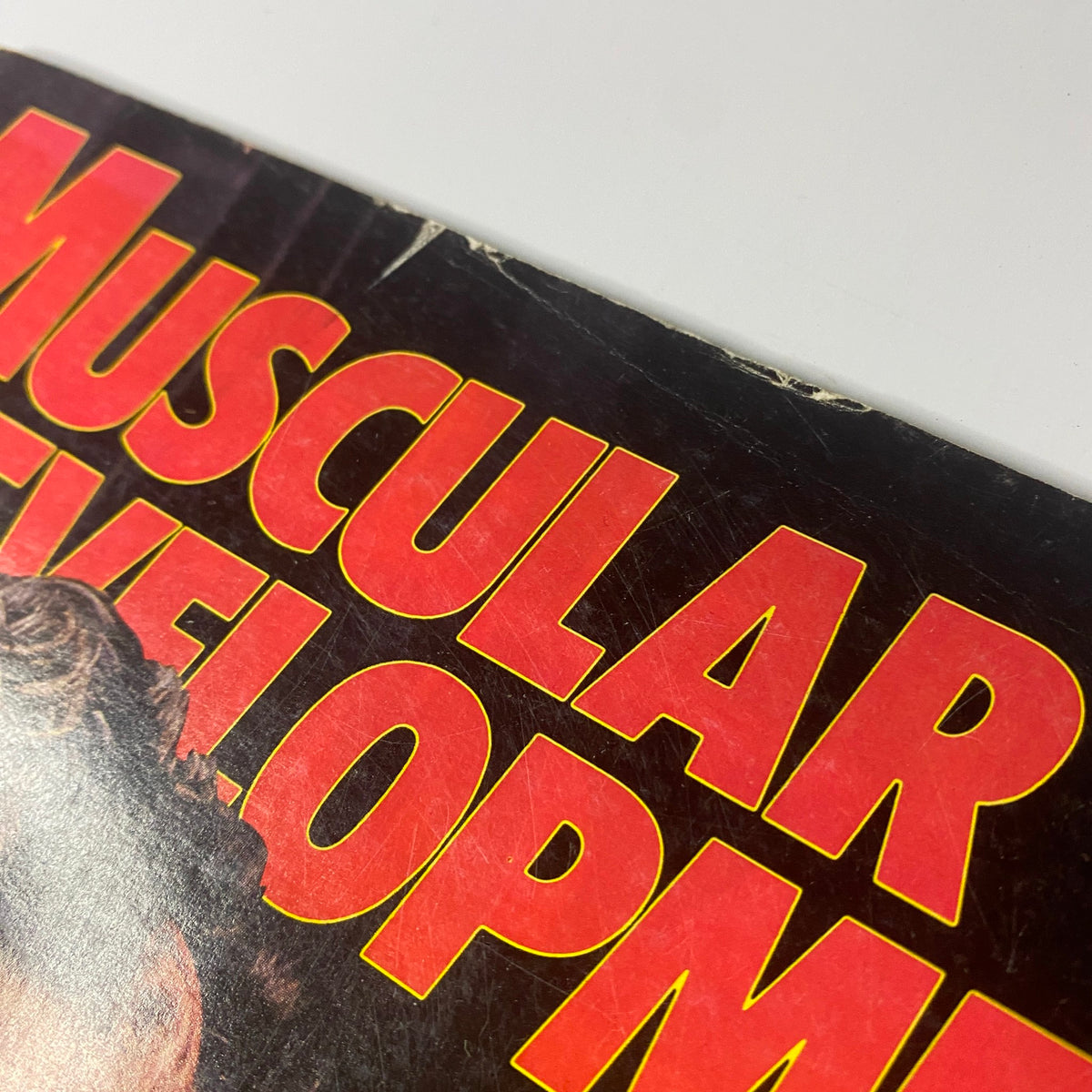 Close-up view of the corner of the Muscular Development Magazine June 1988, showing wear consistent with age on the magazine's cover.