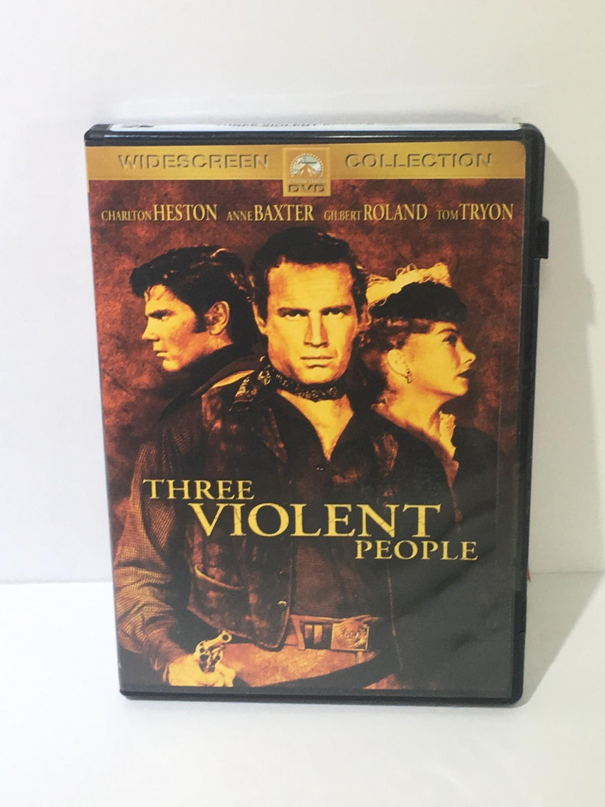 Three Violent People 2005 DVD cover featuring Charlton Heston, Anne Baxter, Gilbert Roland, and Tom Tryon, showcasing the movie title prominently.