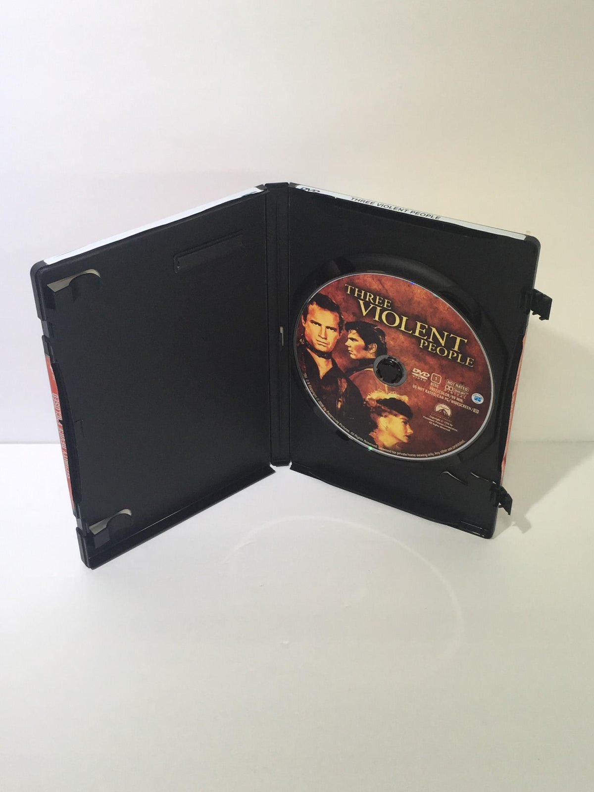 Open Three Violent People 2005 DVD case displaying the disc inside, with the title visible on the disc.