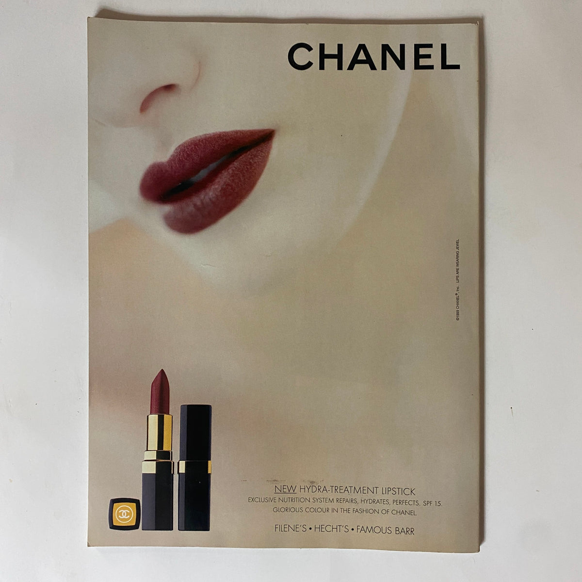 Chanel advertisement for Hydra Treatment Lipstick from a vintage magazine, featuring luxurious lipstick products and a close-up of a model's lips. This ad highlights the glamour and sophistication associated with Chanel.