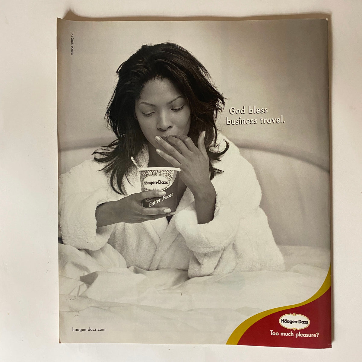 Black and white advertisement for Haagen-Dazs ice cream with a woman enjoying a treat, part of George Magazine August 2000 edition, linked to the cover featuring John F. Kennedy and Jackie Kennedy.