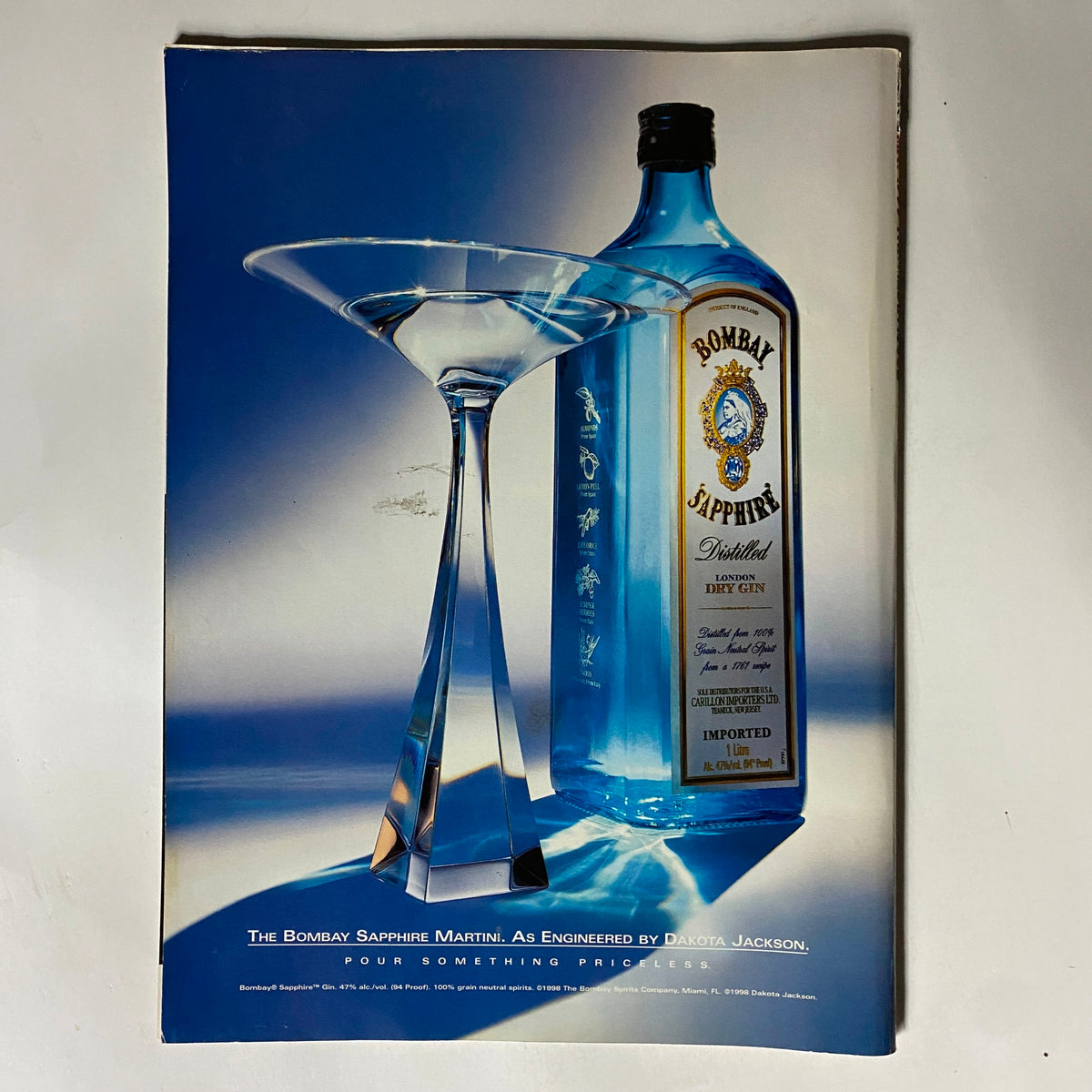 A vintage advertisement from George Magazine May 1999 for Bombay Sapphire Gin, showcasing a martini glass and bottle against a blue background, emphasizing elegance and quality.