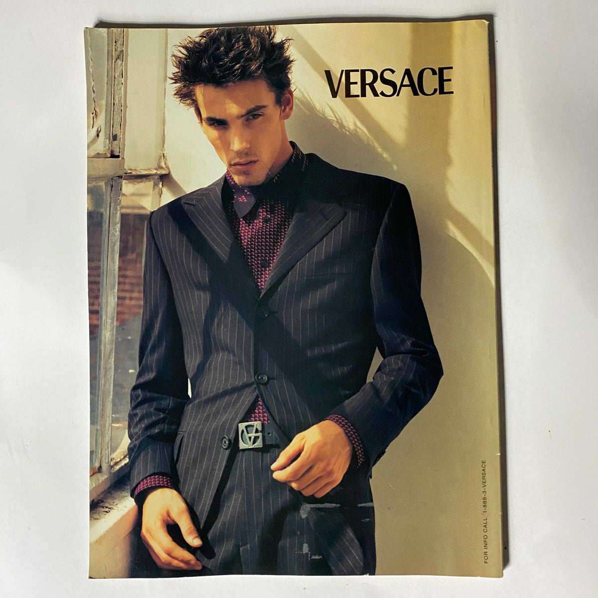 Versace advertisement page from George Magazine March 1999, displaying a model in a tailored suit, emphasizing fashion trends of the late 90s.