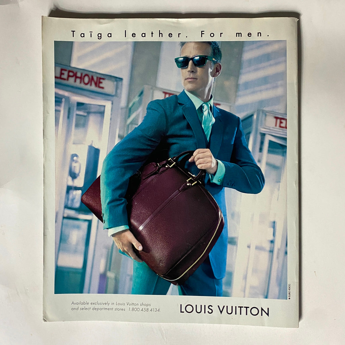 Advertisement for Louis Vuitton featuring a stylish man in a suit carrying a leather bag, illustrating high-end fashion trends aligned with the luxury theme of George Magazine September 1997.
