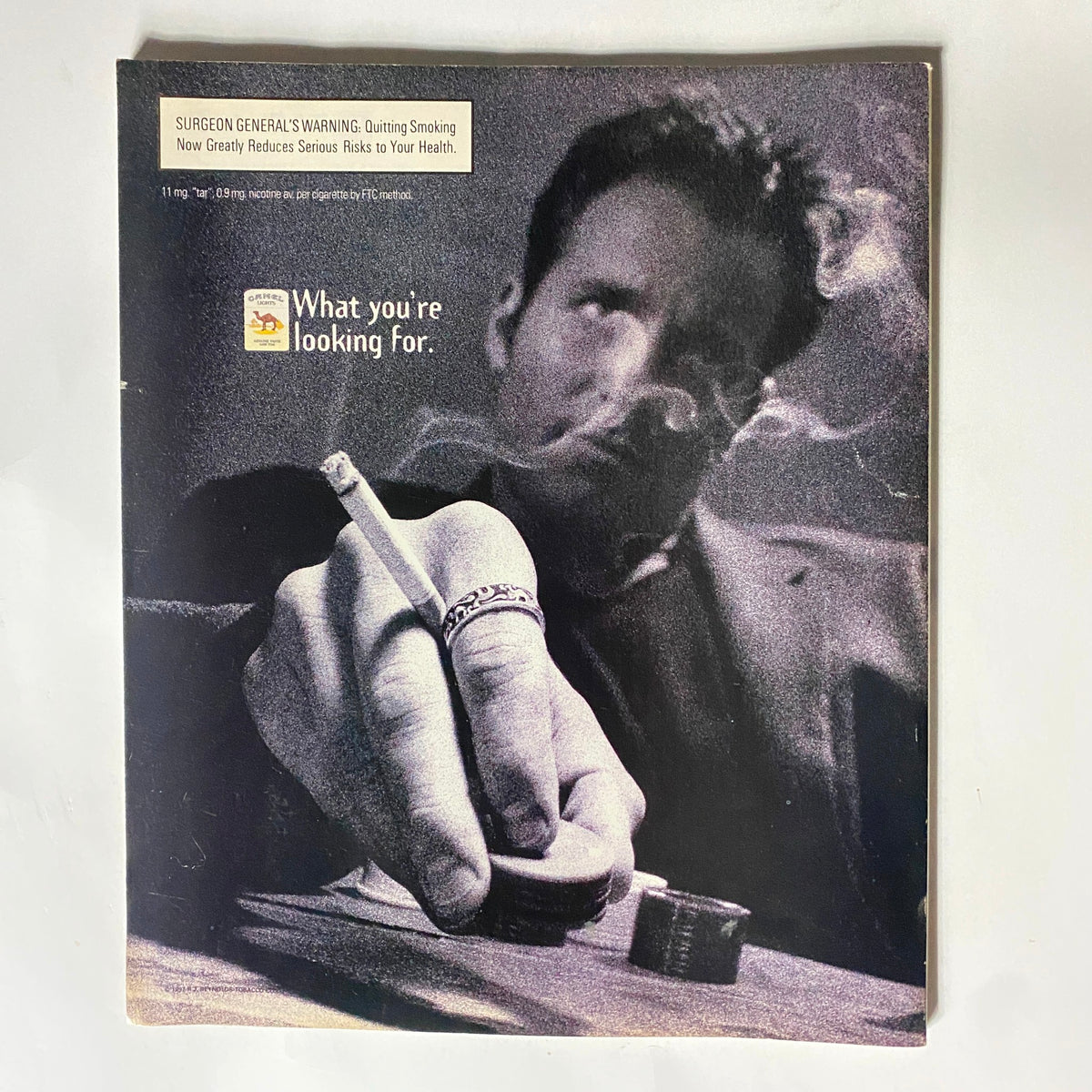Cover image of a vintage magazine showing a man with a cigarette, featuring a warning label about smoking, encapsulating a retro advertising style related to health and lifestyle.