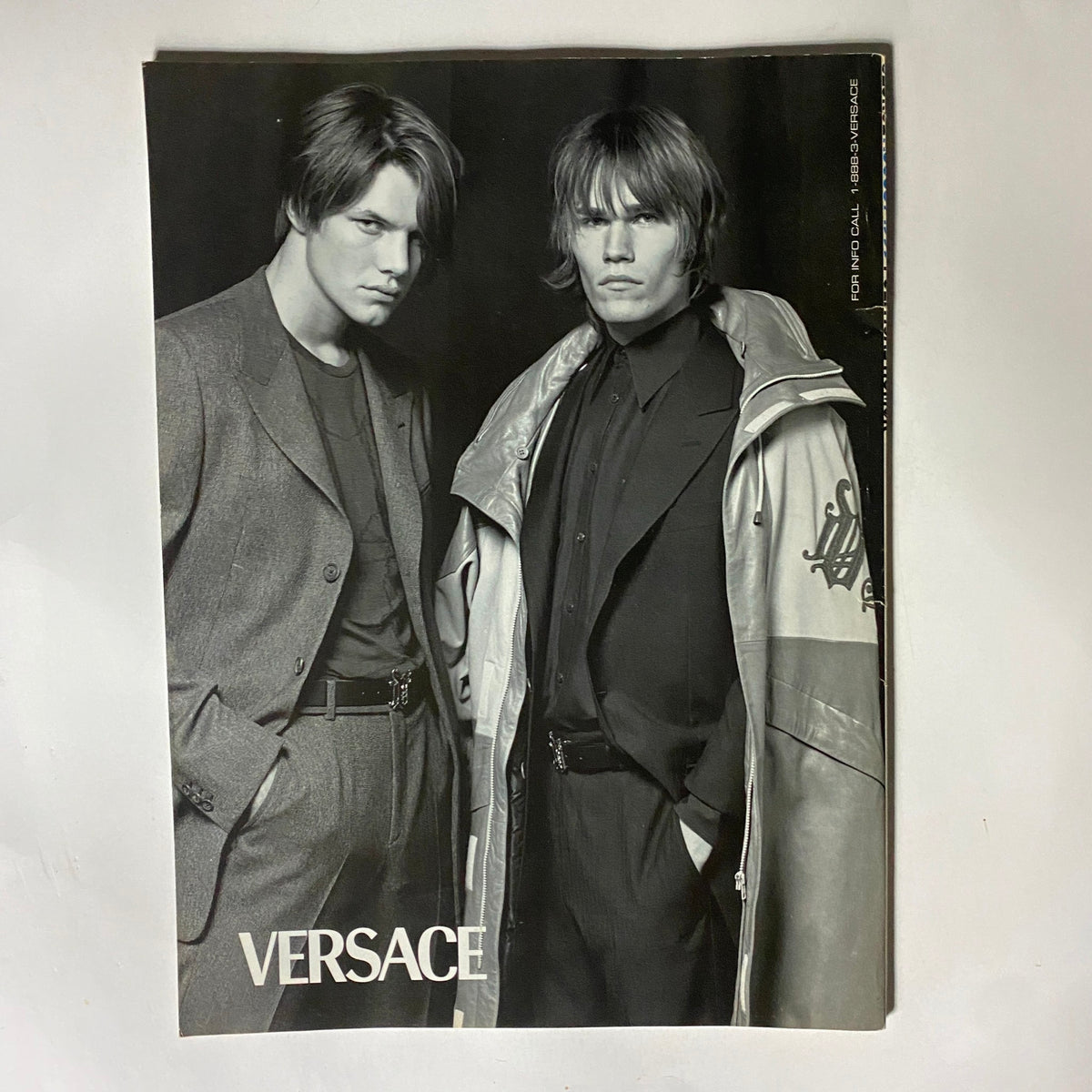 Promotional image featuring two male models in stylish attire for Versace, highlighting fashion trends in the late 90s, showcasing bold styles and brands featured in the George Magazine August 1999 issue.