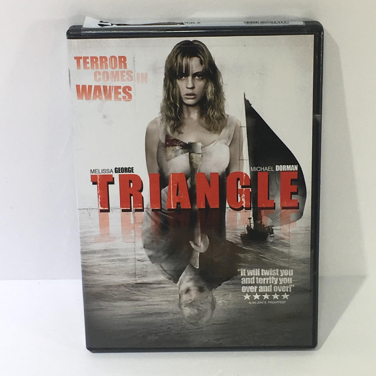 Triangle Melissa George Michael Dorman DVD cover featuring the title 'Triangle' in bold letters, showcasing the film's eerie aesthetic with a reflection of a woman and a sailboat.