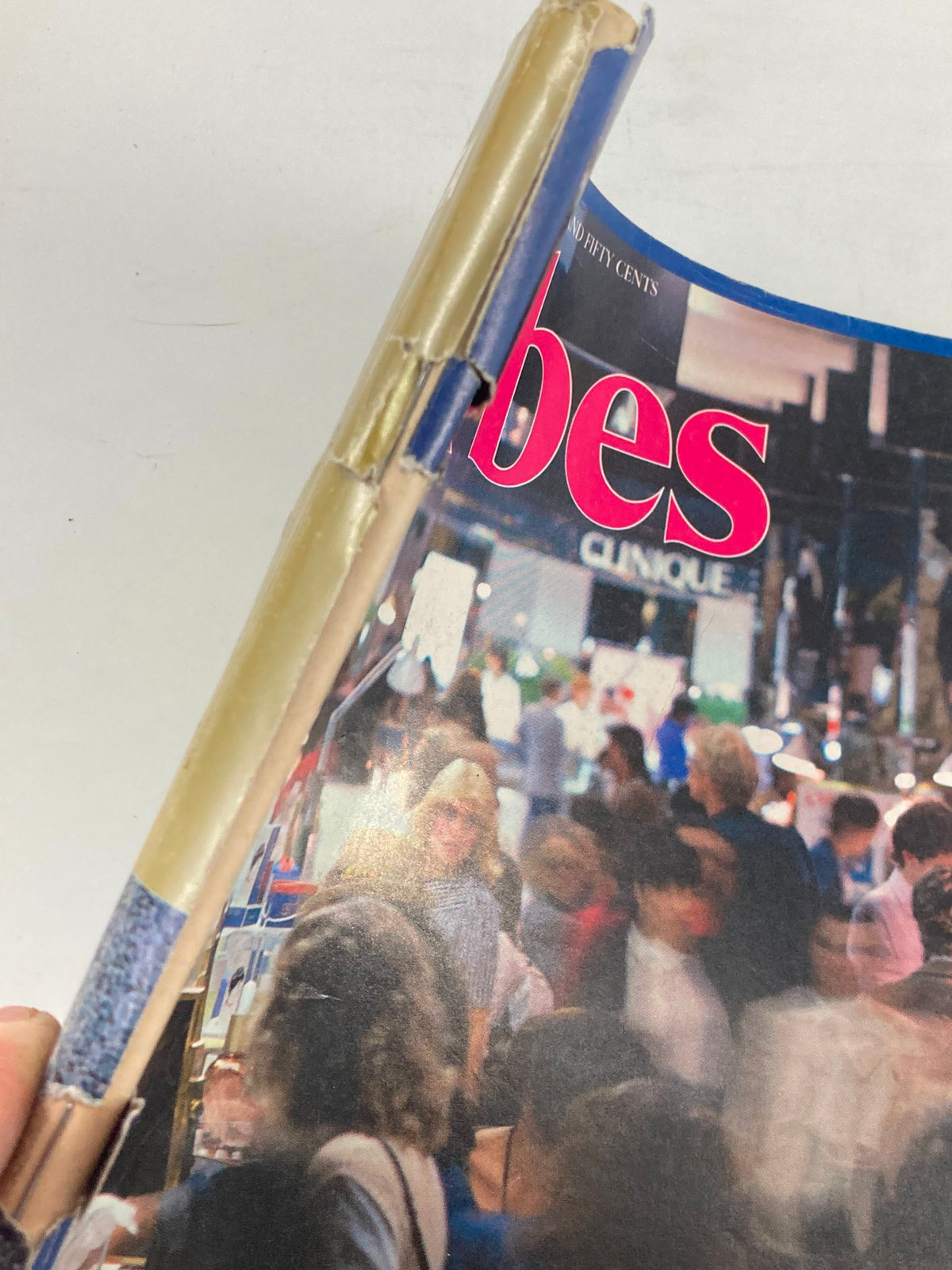 Side view of the spine of Forbes Magazine from October 25, 1982, displaying wear and tear while featuring the title 'The Cosmetics Game Today,' illustrating its vintage condition.