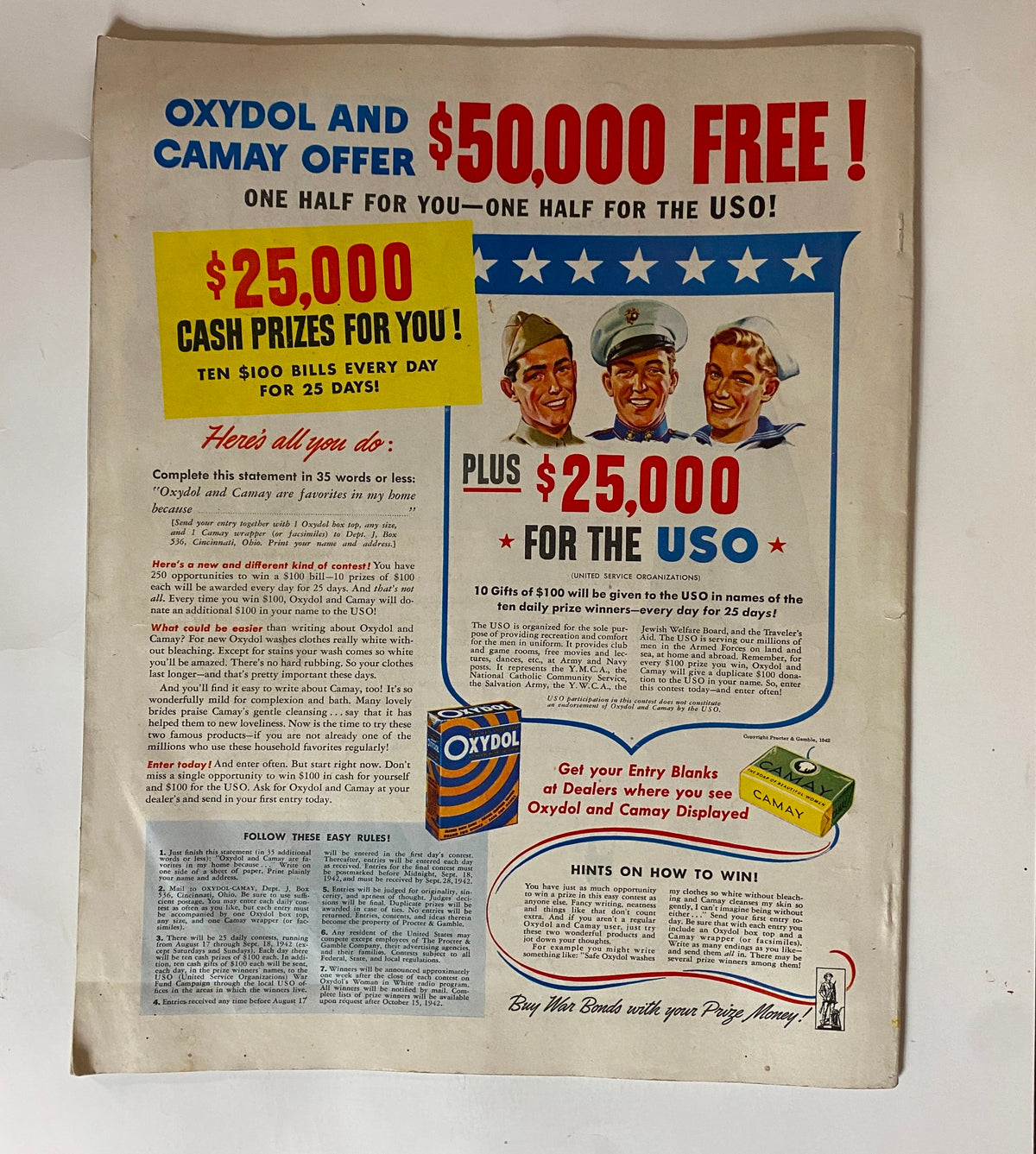 Vintage advertisement from the Ladies' Home Journal Magazine August 1942, highlighting a promotional contest by Oxydol and Camay. The ad features bold text announcing '$50,000 free!' and '$25,000 cash prizes for you!' with military-themed illustrations and product images. This ad reflects the marketing strategies of the 1940s and provides insight into consumer culture during that era.