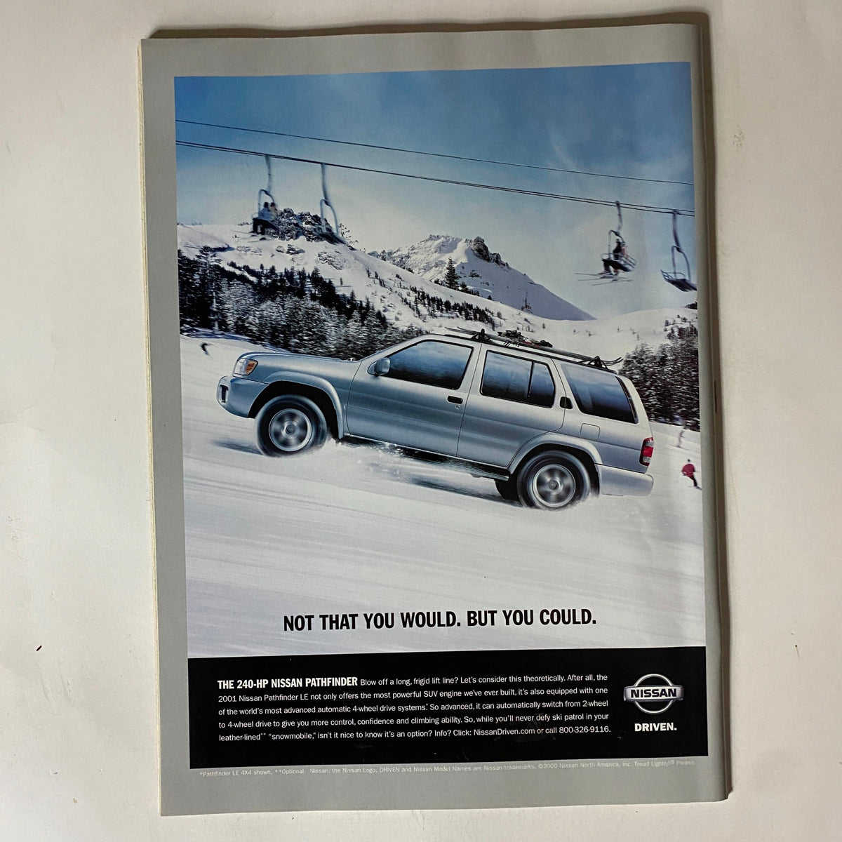 Advertisement page for Nissan Pathfinder in Tennis Magazine October 2000 showcasing the vehicle's capabilities amidst scenic mountains.